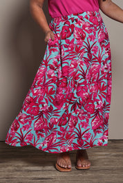 Model Ashleigh wearing size 16 of the Belle Printed Pull On Full Skirt with Pockets in colour Aquafusch (Pink), from the front, cropped image