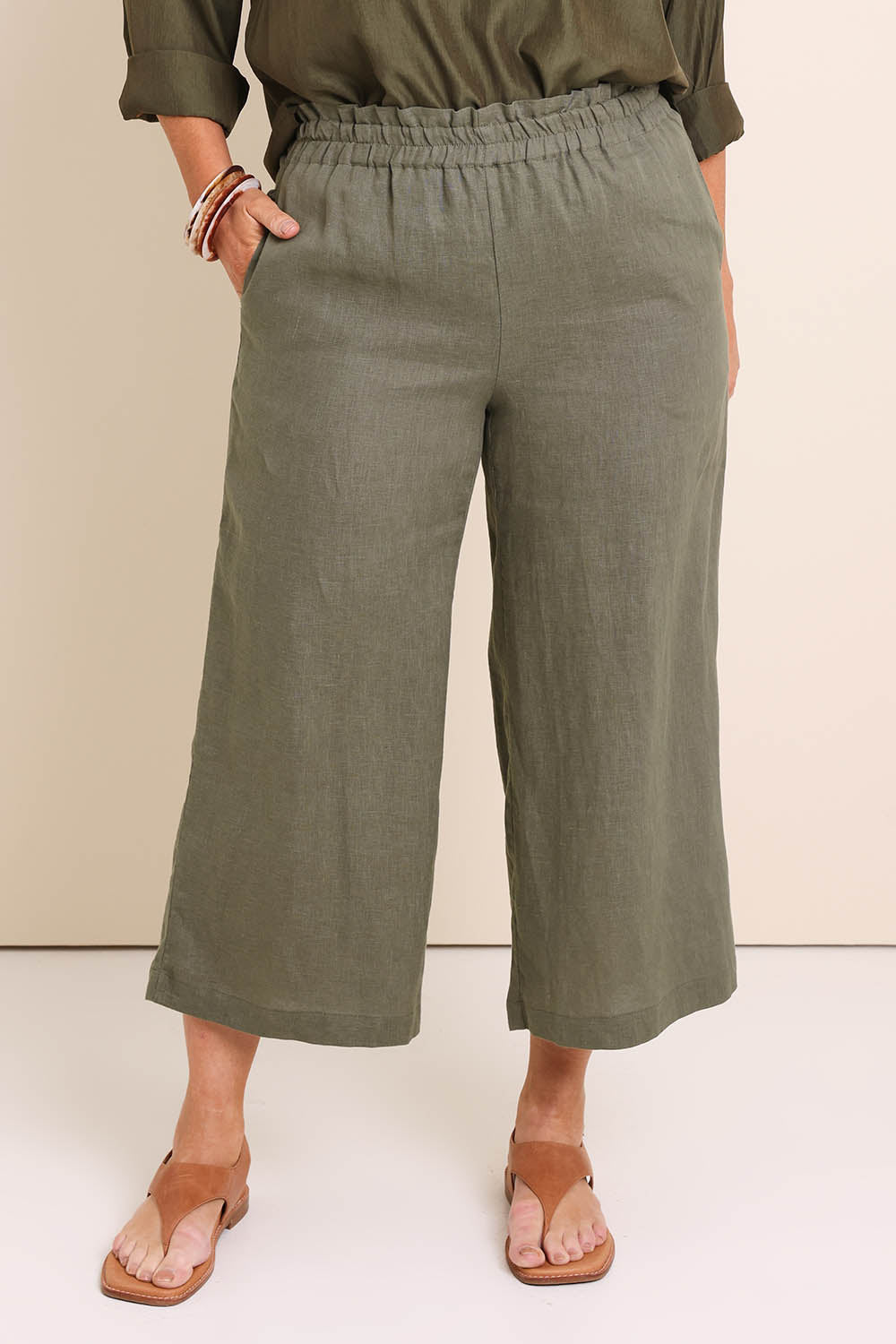 Model Lauraw wearing size 14 of the Belle Easy Wear Linen Pant – Olive in colour Olive, in a cropped view
