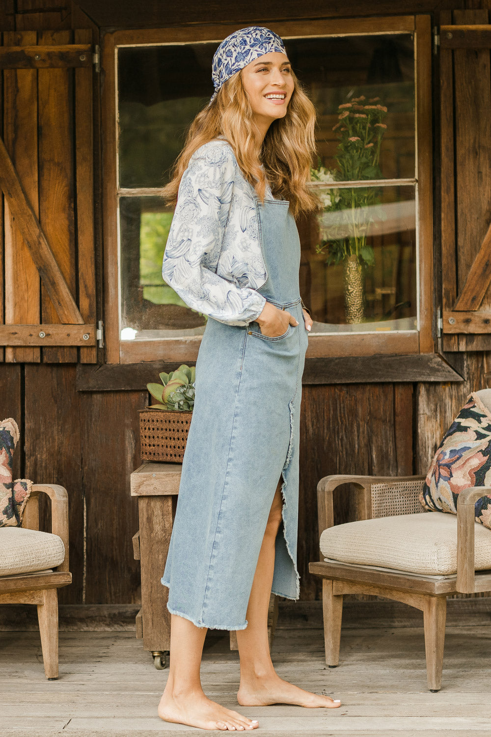 Model Ilona wearing size 10 of the Happy Me Denim Pinny in colour Denim (Blue), from the front, showing the whole outfit