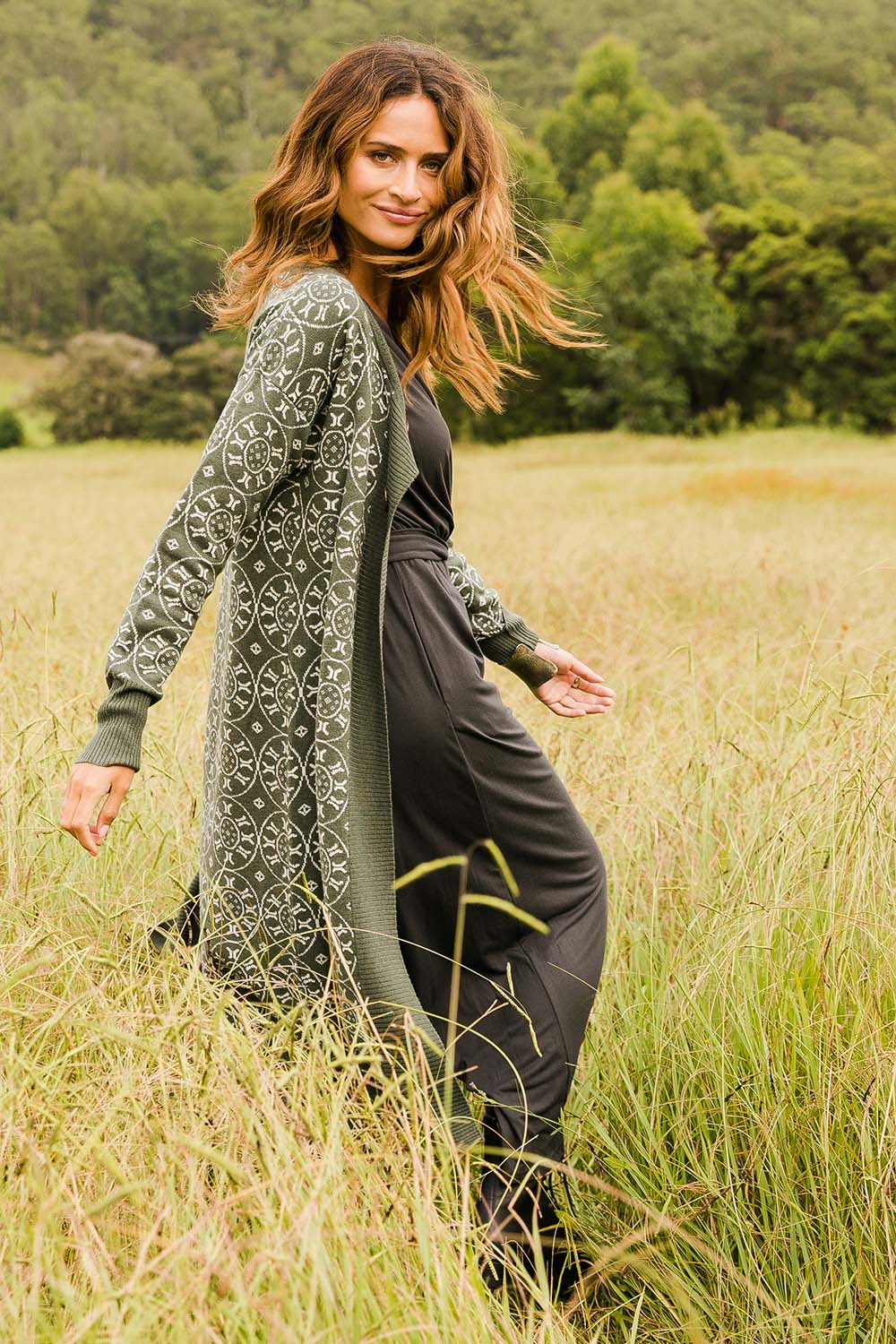 Model Ilona wearing size S of the Fields Of Folly Cardi in colour Forest (Green), from the front, showing the whole outfit