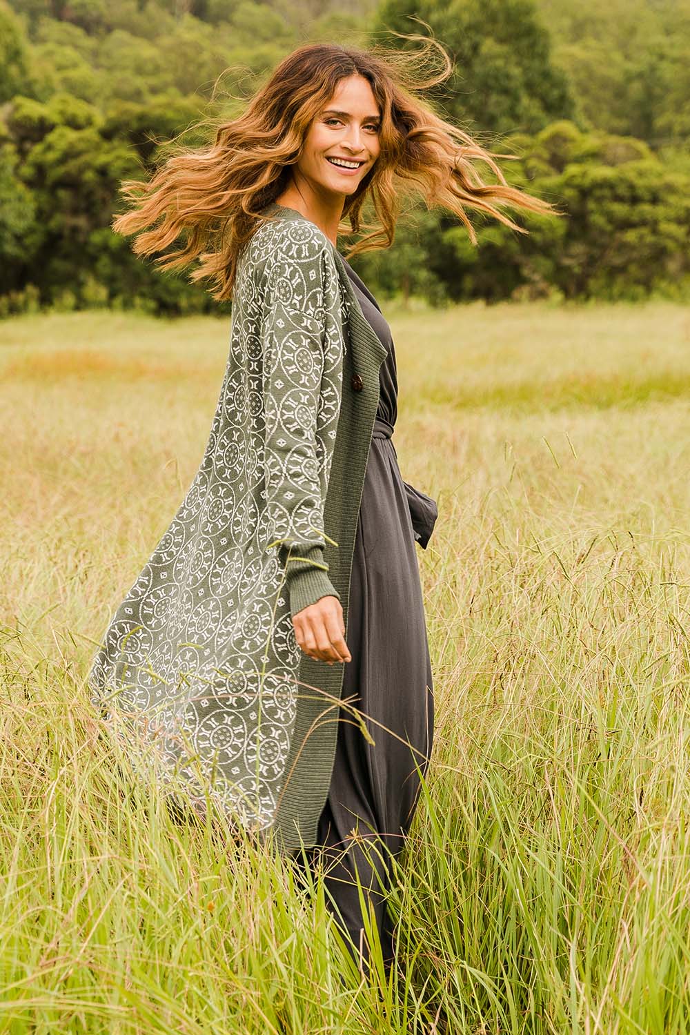 Model Ilona wearing size S of the Fields Of Folly Cardi in colour Forest (Green), from the front, showing the whole outfit