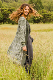 Model Ilona wearing size S of the Fields Of Folly Cardi in colour Forest (Green), from the front, showing the whole outfit