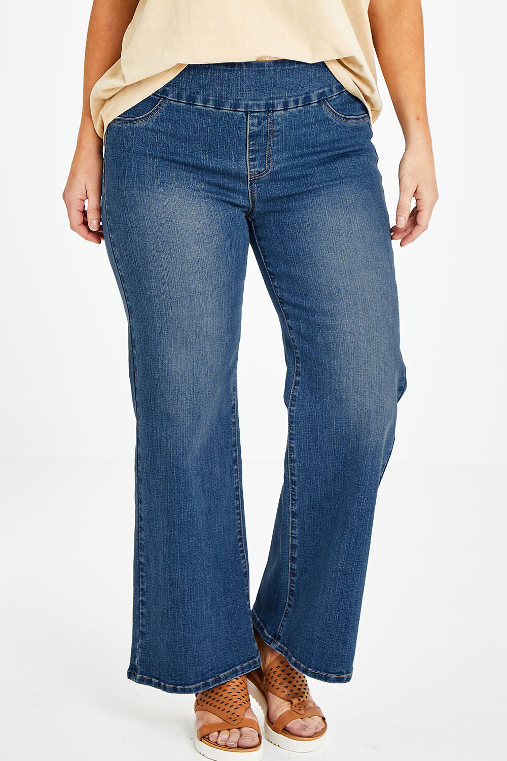 Model Laura wearing size 14 of the Easy As Pull On Jeans in colour Denim (Blue), from the front, cropped image