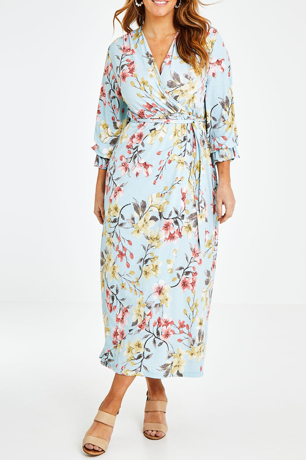 Model Laura wearing size 14 of the Freedom Faux Wrap Maxi Dress in colour Blossom (Blue), from the front, cropped image