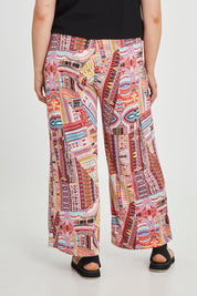 Model Keeara wearing size 16 of the Pretty Patch Pants in colour Bright (Red), from the back