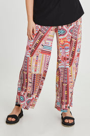 Model Keeara wearing size 16 of the Pretty Patch Pants in colour Bright (Red), from the front, cropped image