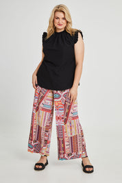 Model Keeara wearing size 16 of the Pretty Patch Pants in colour Bright (Red), from the front, showing the whole outfit