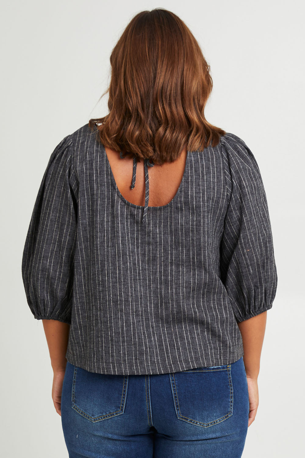 Model Monique wearing size 14 of the Ive Got Your Back Blouse in colour Blackwhite (Black), from the back