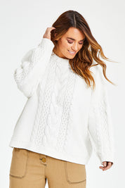 Model Laura wearing size L of the Cosy In Cable Crew Neck Jumper in colour Snow (White), from the front, cropped image