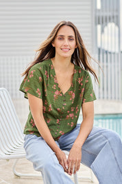 Model Tegand wearing size 10 of the Cute As A Button Printed Blouse - Greenpink in colour Greenpink, in a cropped view