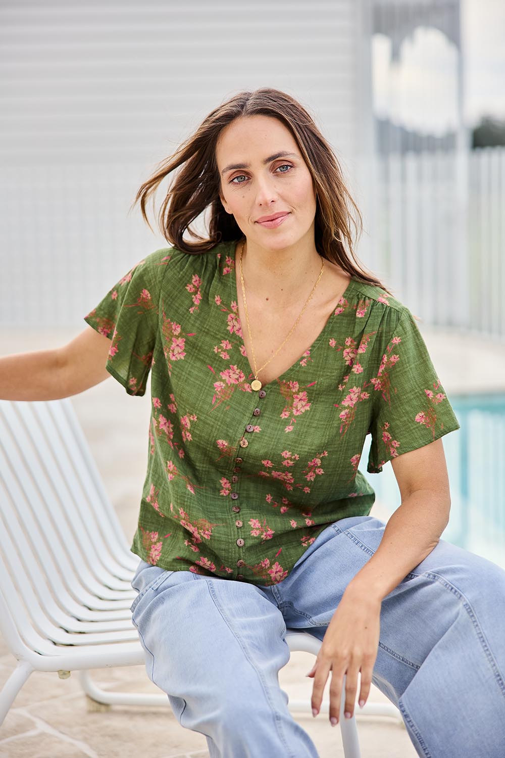 Model Tegand wearing size 10 of the Cute As A Button Printed Blouse - Greenpink in colour Greenpink, in a cropped view