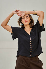 Model Tegand wearing size 10 of the Cute As A Button Cotton Blouse - Black in colour Black, in a cropped view