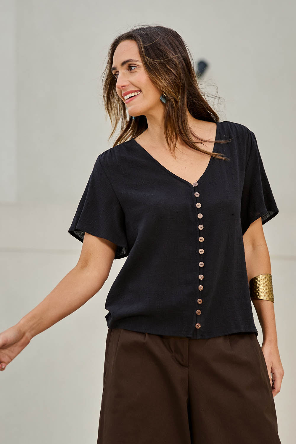 Model Tegand wearing size 10 of the Cute As A Button Cotton Blouse - Black in colour Black, in a cropped view