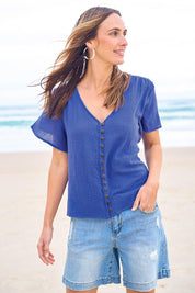 Model Tegand wearing size 10 of the Cute As A Button Cotton Blouse - Blue in colour Blue, from an angle