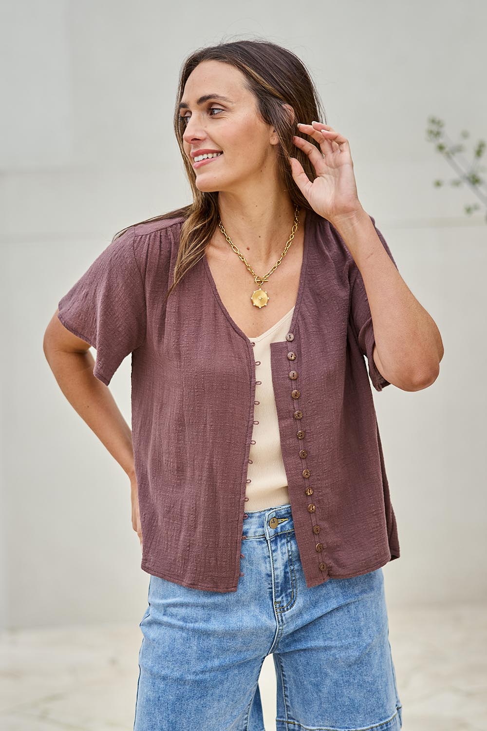 Model Tegand wearing size 10 of the Cute As A Button Blouse – Chocolate in colour Chocolate, from an angle