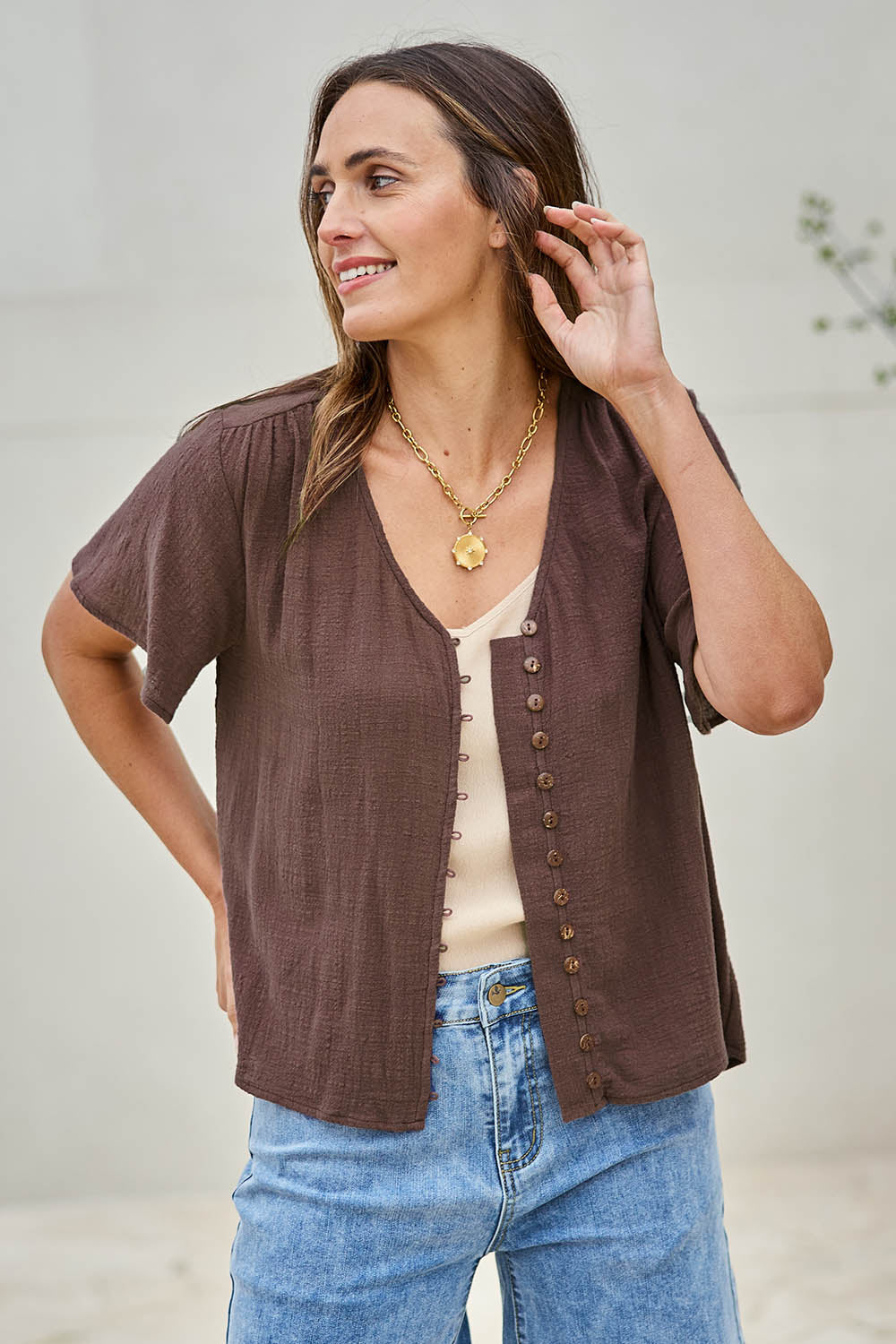 Model Tegand wearing size 10 of the Cute As A Button Blouse – Chocolate in colour Chocolate, from an angle