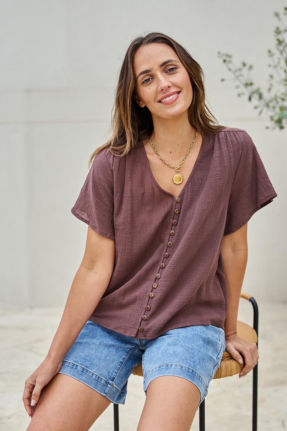 Model Tegand wearing size 10 of the Cute As A Button Blouse – Chocolate in colour Chocolate, in a cropped view