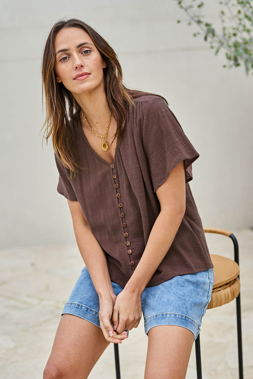 Model Tegand wearing size 10 of the Cute As A Button Blouse – Chocolate in colour Chocolate, in a cropped view