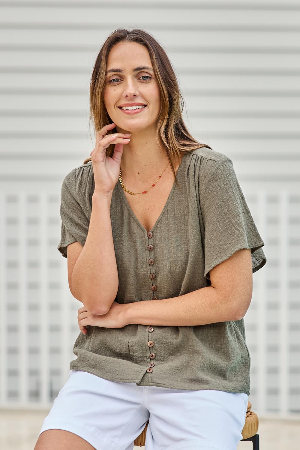 Model Tegand wearing size 10 of the Cute As A Button Blouse – Forrest in colour Forrest, in a cropped view
