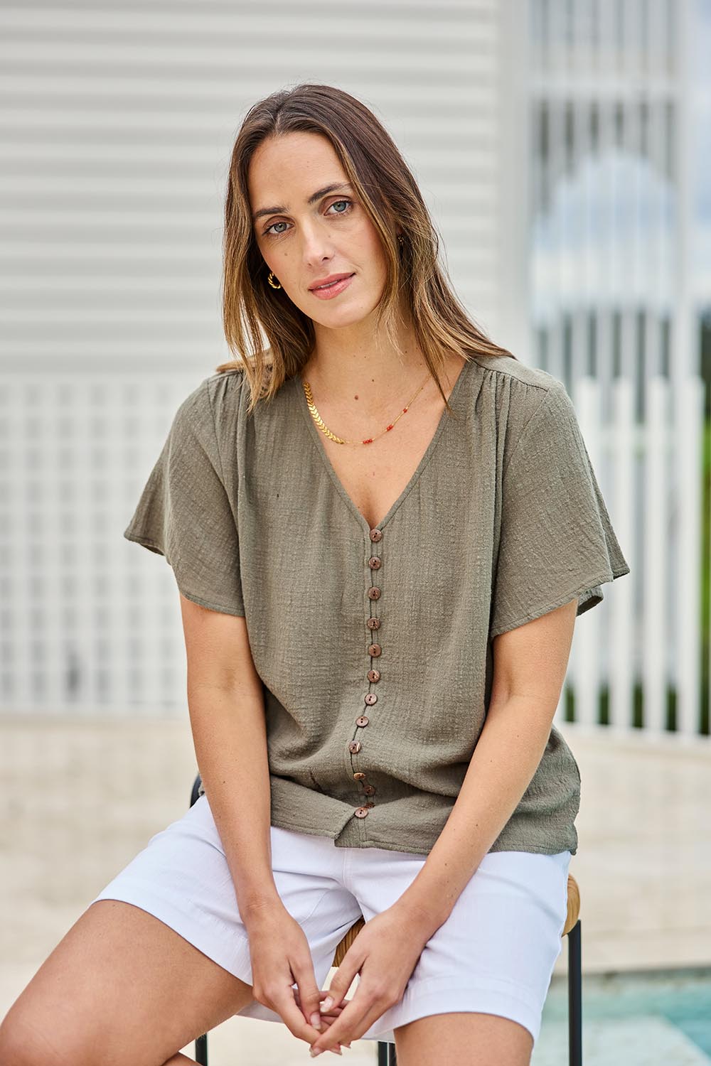 Model Tegand wearing size 10 of the Cute As A Button Blouse – Forrest in colour Forrest, in a cropped view