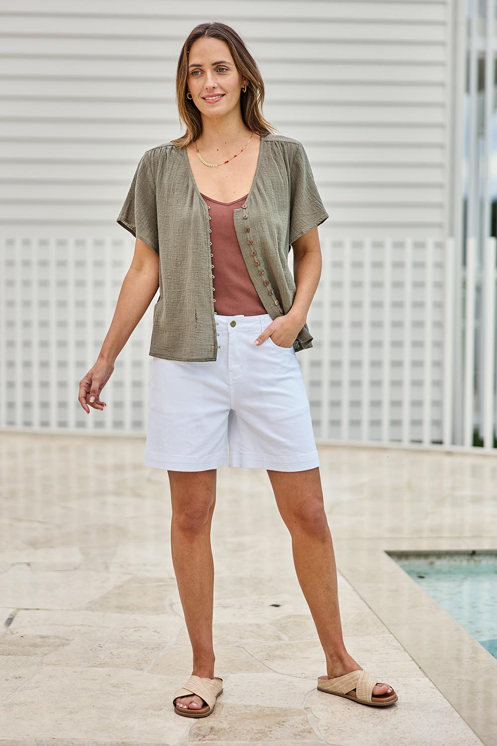Model Tegand wearing size 10 of the Cute As A Button Blouse – Forrest in colour Forrest, from the front