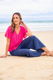 Model Tegan wearing size 10 of the Cute As A Button Blouse in colour Hotpink (Pink), from the front, showing the whole outfit