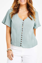 Model Laura wearing size 14 of the Cute As A Button Blouse in colour Sage (Green), from the front, cropped image