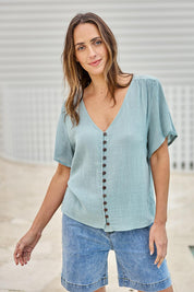 Model Tegand wearing size 10 of the Cute As A Button Blouse - Sage in colour Sage, in a cropped view