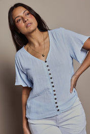 Model Tahneei wearing size 10 of the Cute As A Button Cotton Blouse - Sky in colour Sky, from an angle