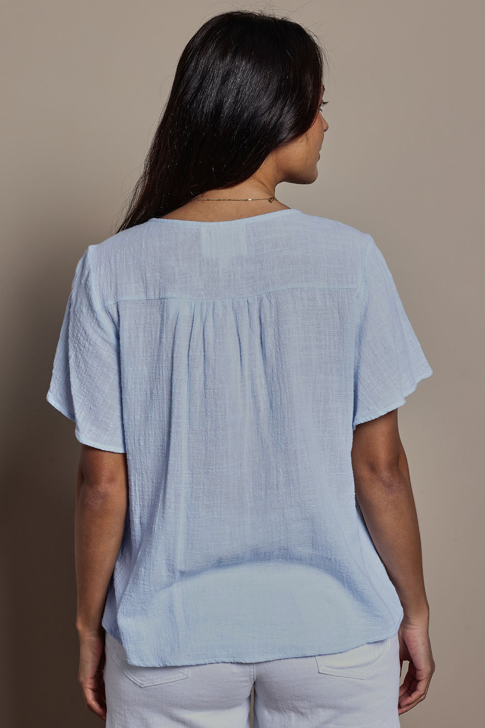 Model Tahneei wearing size 10 of the Cute As A Button Cotton Blouse - Sky in colour Sky, from the back