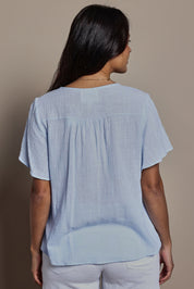 Model Tahneei wearing size 10 of the Cute As A Button Cotton Blouse - Sky in colour Sky, from the back
