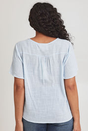 Model Terri-Leigh wearing size 14 of the Cute As A Button Blouse in colour Sky (Blue), from the back