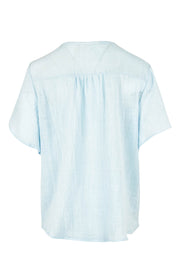Product shot of the Cute As A Button Blouse in colour Sky (Blue), from the back