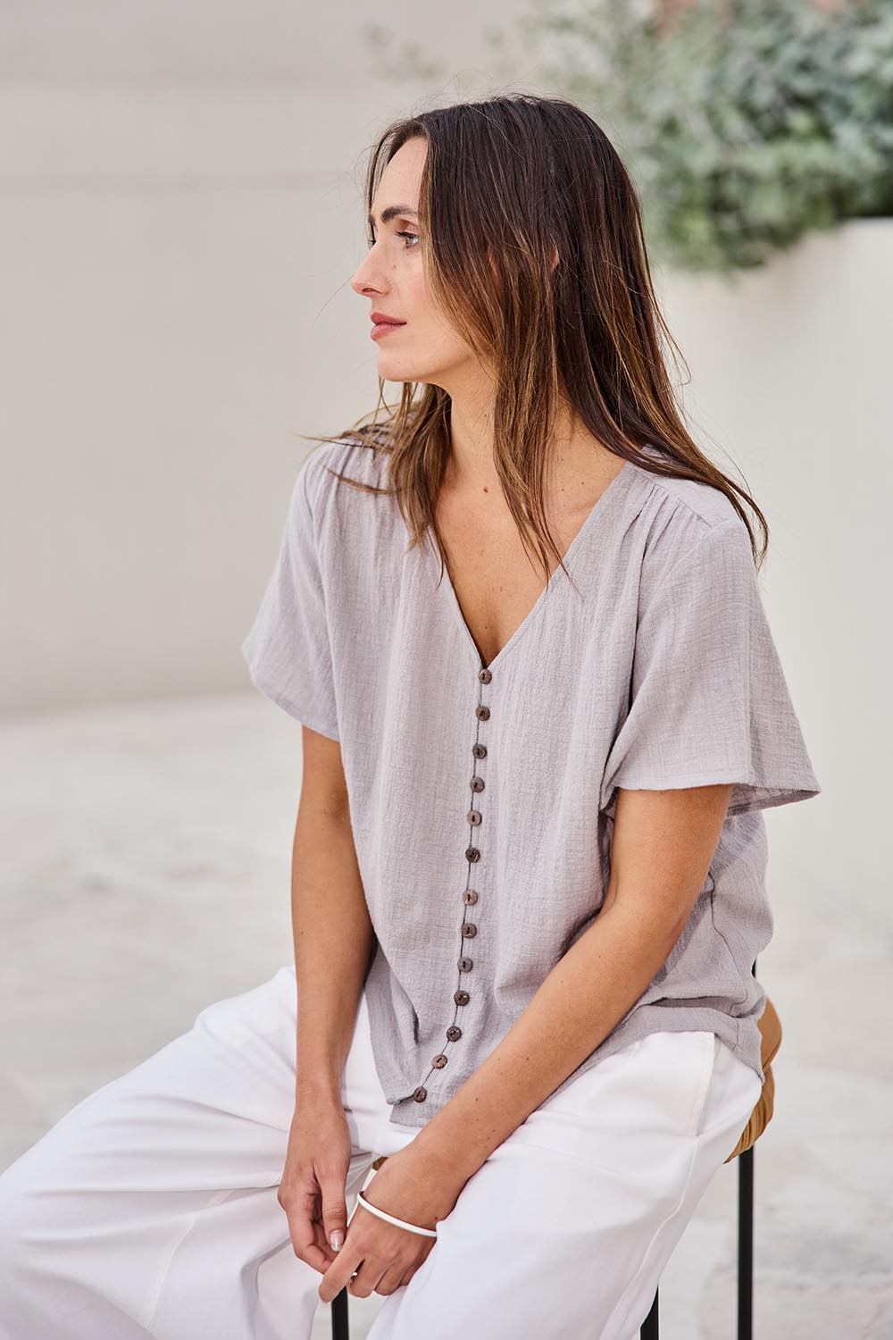 Model Tegand wearing size 10 of the Cute As A Button Blouse – Smoke in colour Smoke, from an angle