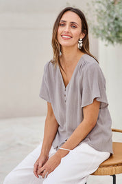 Model Tegand wearing size 10 of the Cute As A Button Cotton Blouse – Smoke in colour Smoke, in a cropped view