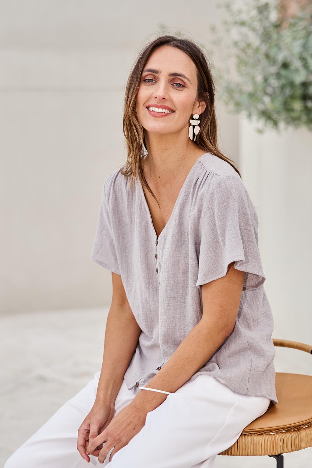Model Tegand wearing size 10 of the Cute As A Button Blouse – Smoke in colour Smoke, in a cropped view