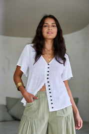 Model Tahnee wearing size 10 of the Cute As A Button Blouse in colour White (White), from the front, showing the whole outfit