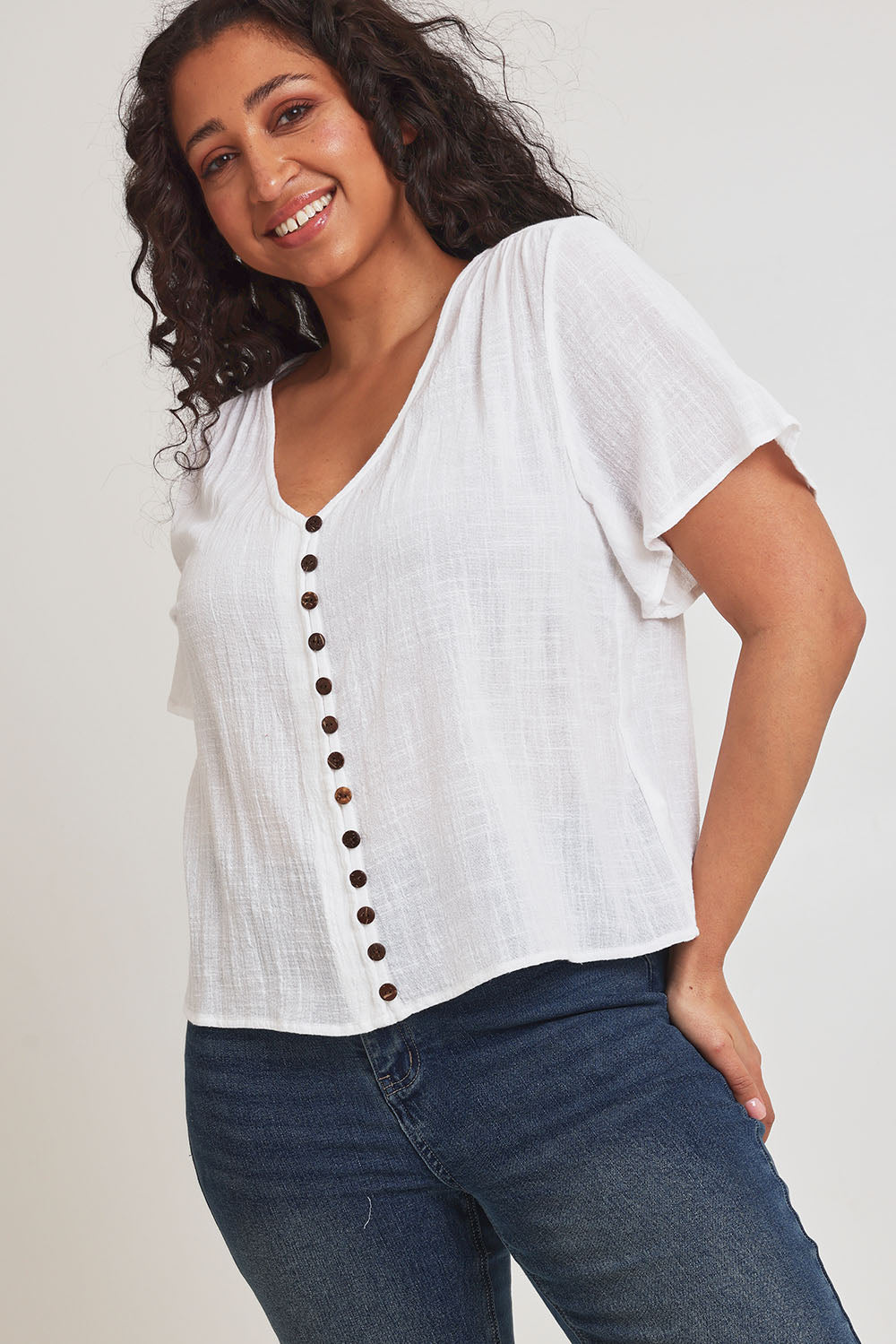 Model Terri-Leigh wearing size 14 of the Cute As A Button Blouse in colour White (White), from the front, cropped image