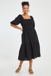 Model Noli wearing size 14 of the Wandering In Fields Organic Cotton Dress in colour Black (Black), from the front, showing the whole outfit