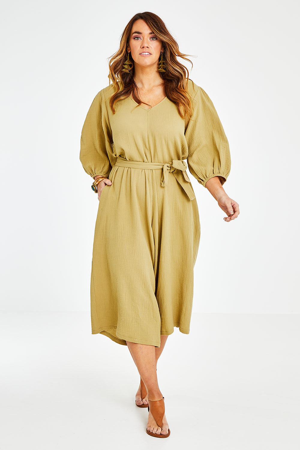 Model Laura wearing size 14 of the A Spring In My Step Jumpsuit in colour Olive (Green), from the front, showing the whole outfit