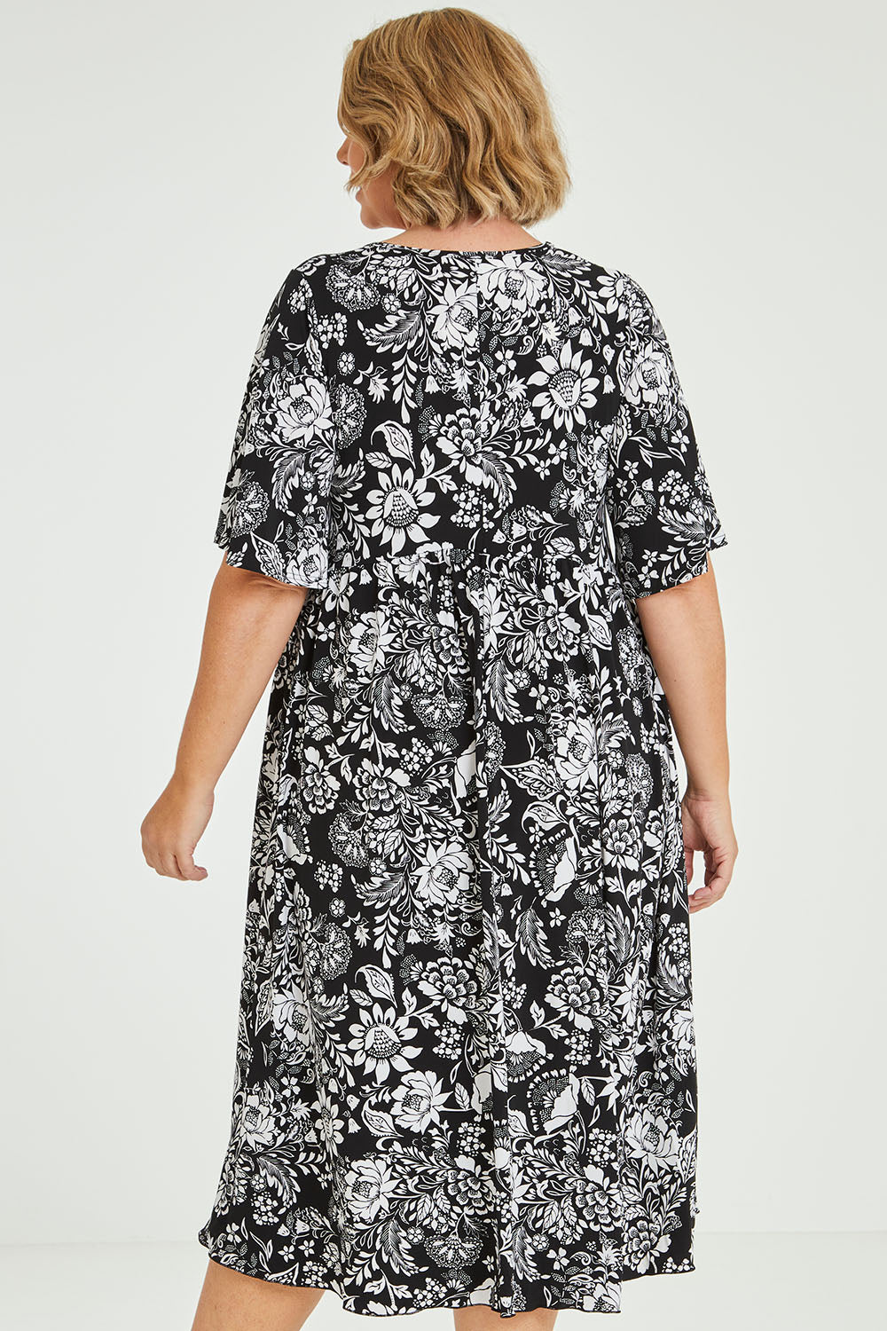 Model Fiona wearing size 16 of the Swinging Hands With You Dress in colour Blackfleur (Black), from the back
