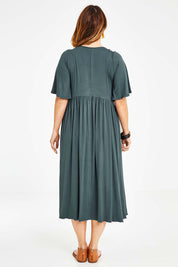 Model Laura wearing size 14 of the Swinging Hands With You Dress in colour Army (Green), from the back