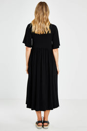 Model Kelly wearing size 10 of the Swinging Hands With You Dress in colour Black (Black), from the back