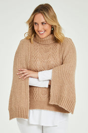 Model Jess wearing size L of the My Obsession Is You Poncho in colour Camel, from the front, cropped image