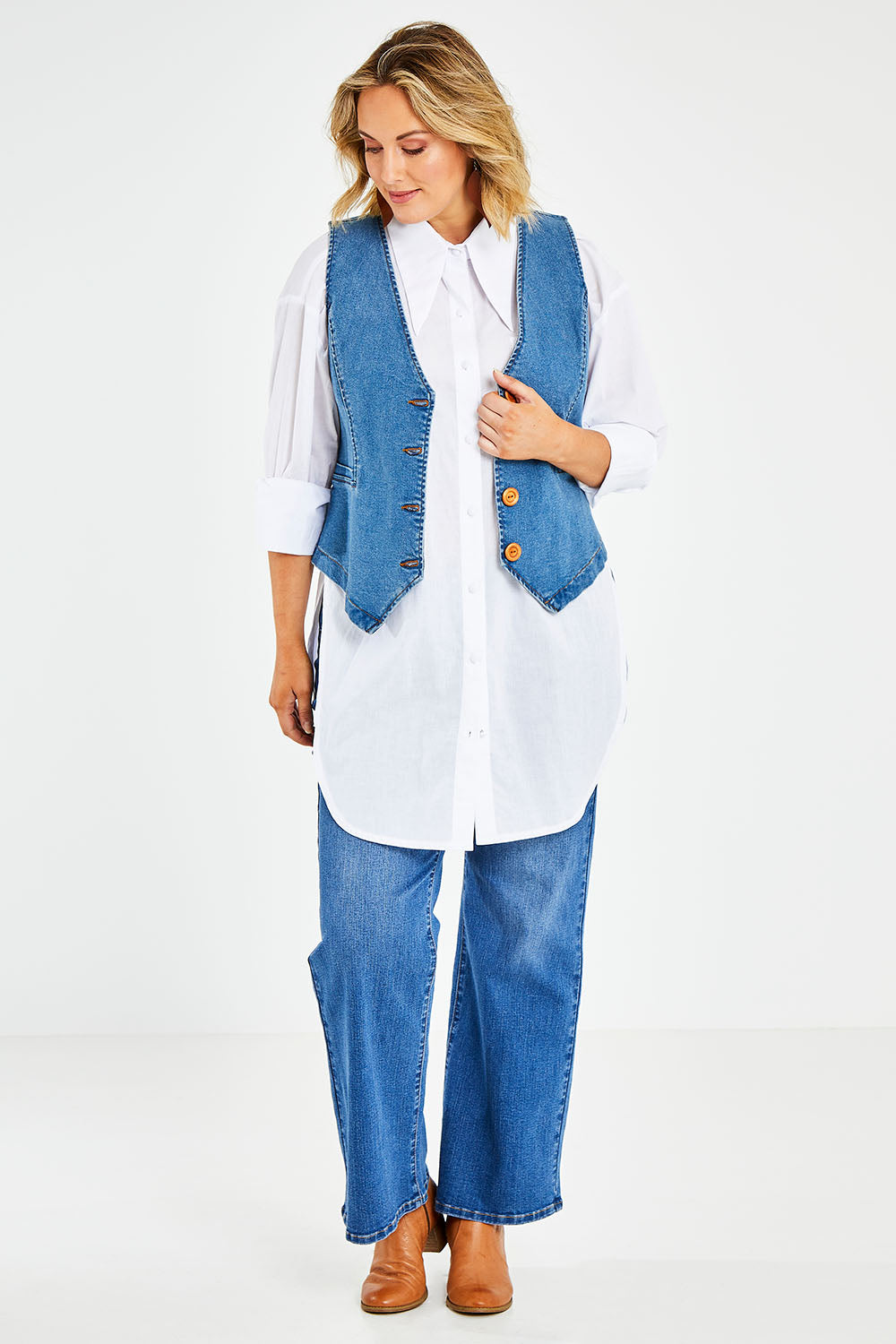 Model Jess wearing size 14 of the Fine and Dandy Denim Vest in colour Denim (Blue), from the front, showing the whole outfit