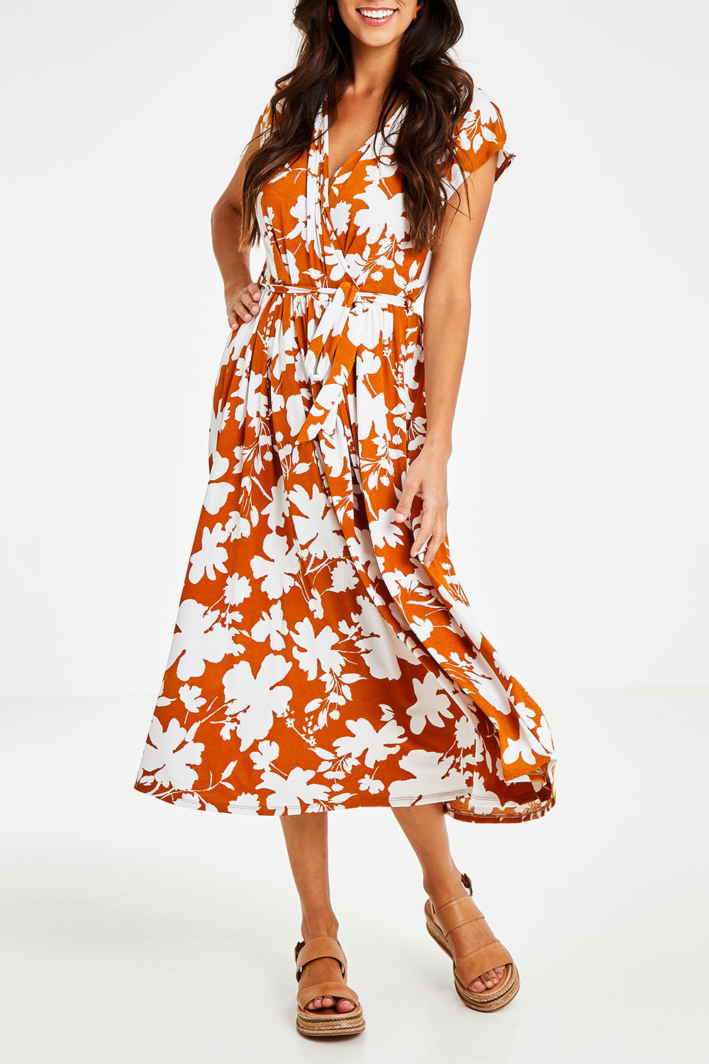 Model Vitoria wearing size 10 of the Feels Like Summer Wrap Dress in colour Rust, from the front, cropped image