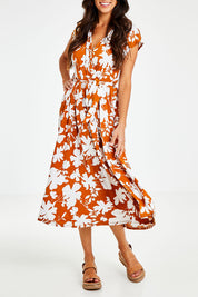 Model Vitoria wearing size 10 of the Feels Like Summer Wrap Dress in colour Rust, from the front, cropped image