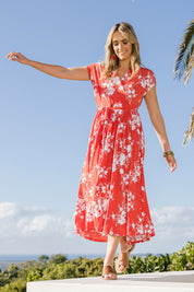 Model Tegan wearing size 10 of the Feels Like Summer Wrap Dress in colour Tomato (Red), from the front, showing the whole outfit