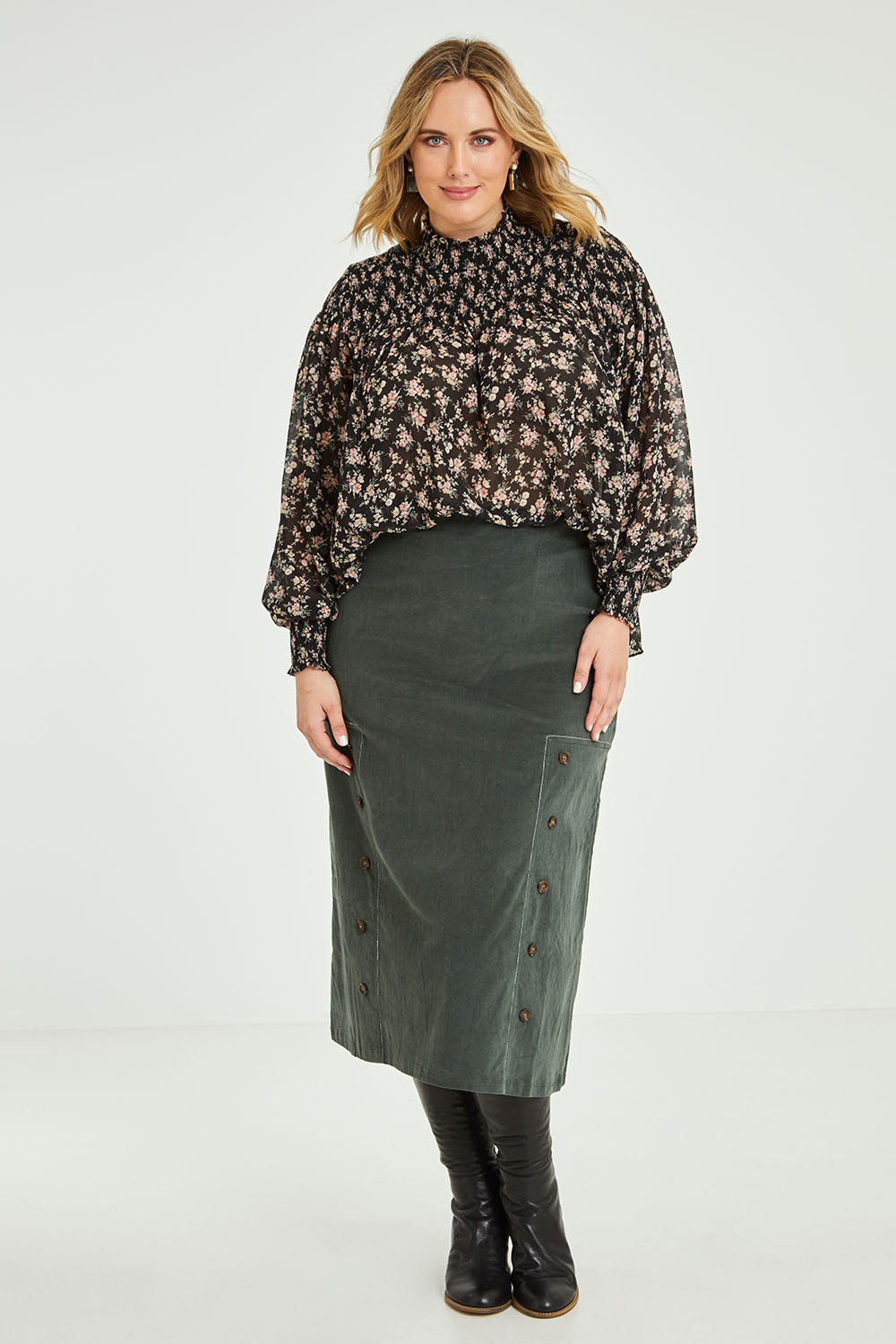 Model Jess wearing size 14 of the Smooth Lines Stretch Cord Skirt in colour Khaki (Green), from the front, showing the whole outfit