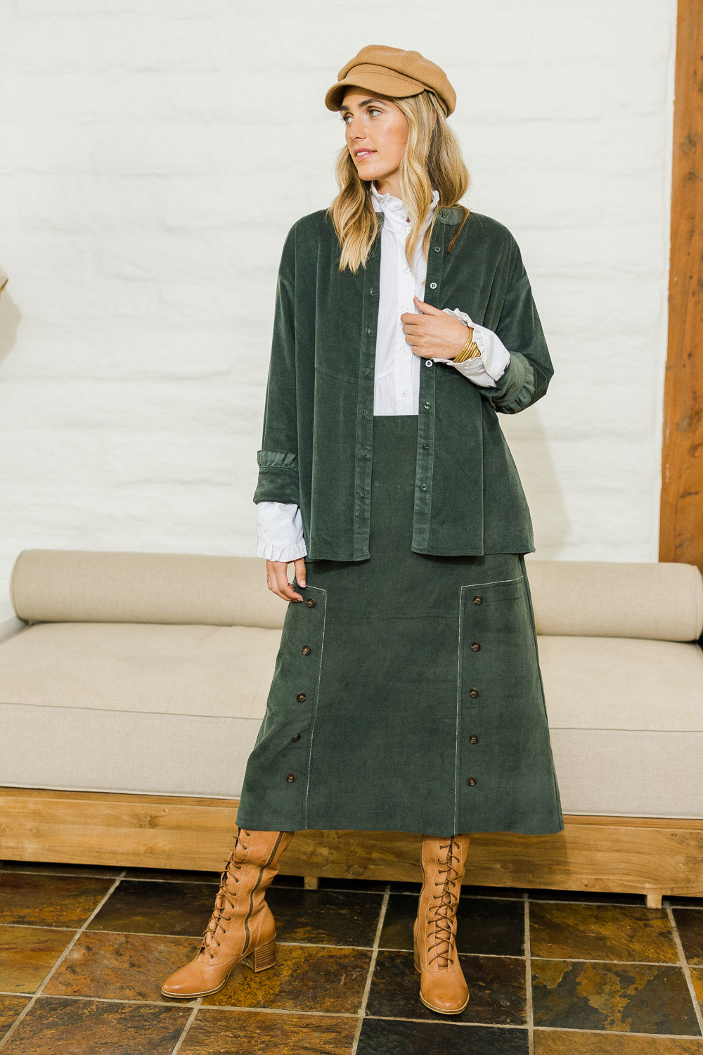 Model Tegan wearing size 10 of the Smooth Lines Stretch Cord Skirt in colour Khaki (Green), from the front, showing the whole outfit
